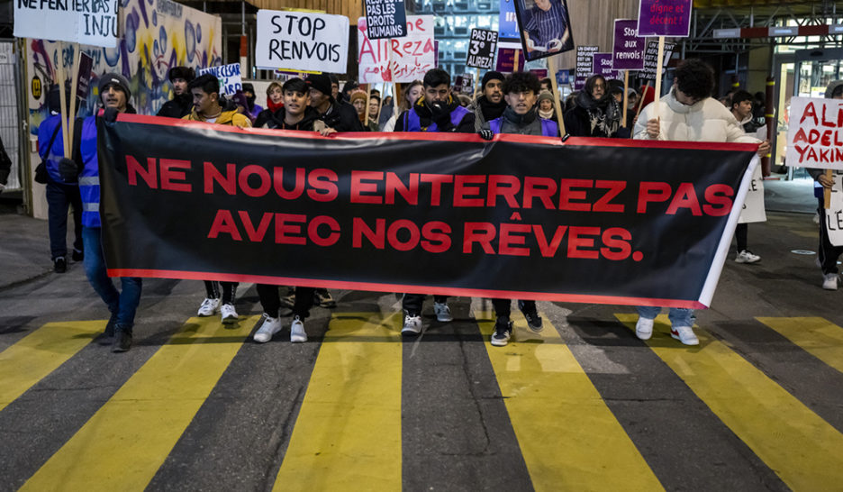 Drapeau rouge contre les renvois de réfugié·es